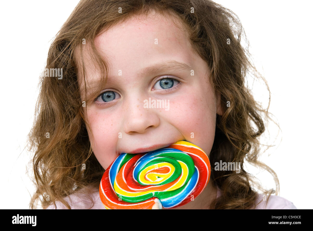Ein junges Mädchen saugt an einem Pin Rad Süßigkeiten Sauger mit Freude Stockfoto