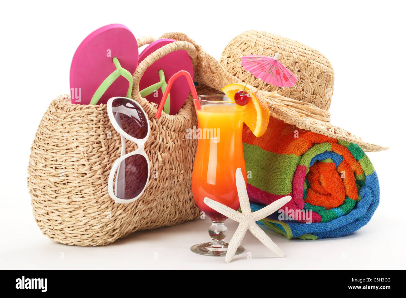 Strandtasche mit Handtuch, Flip-Flops, Sonnenbrillen und ein Glas Cocktail. Isoliert auf weißem Hintergrund. Stockfoto