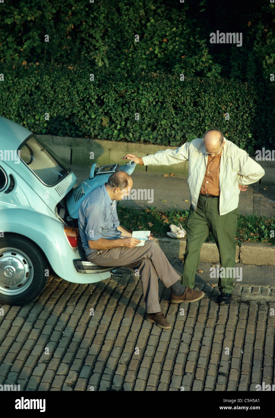 Nachbarn lesen Reparaturanleitung VW-Käfer in Pittsburgh Street Stockfoto