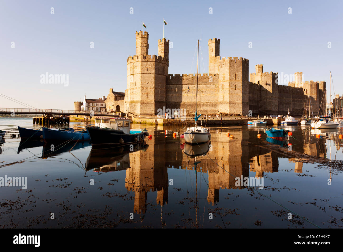 Caernarfon Castle, North Wales, mit festgemachten Booten im Vordergrund Stockfoto