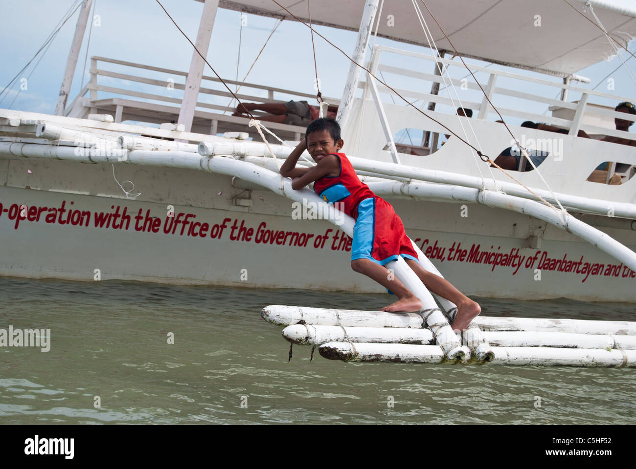 Ein Filipino junge auf einem Passagier Auslegerboot nach Malapascua Island Stockfoto