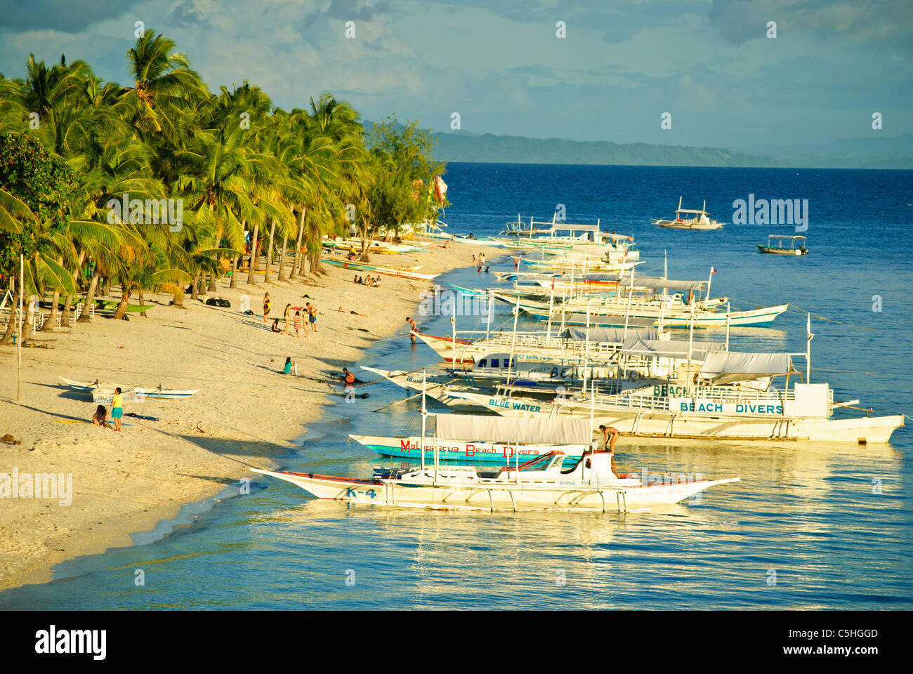 Ausleger als Tauchboote festmachen entlang des Strandes von Malapascua Island, Philippinen Stockfoto