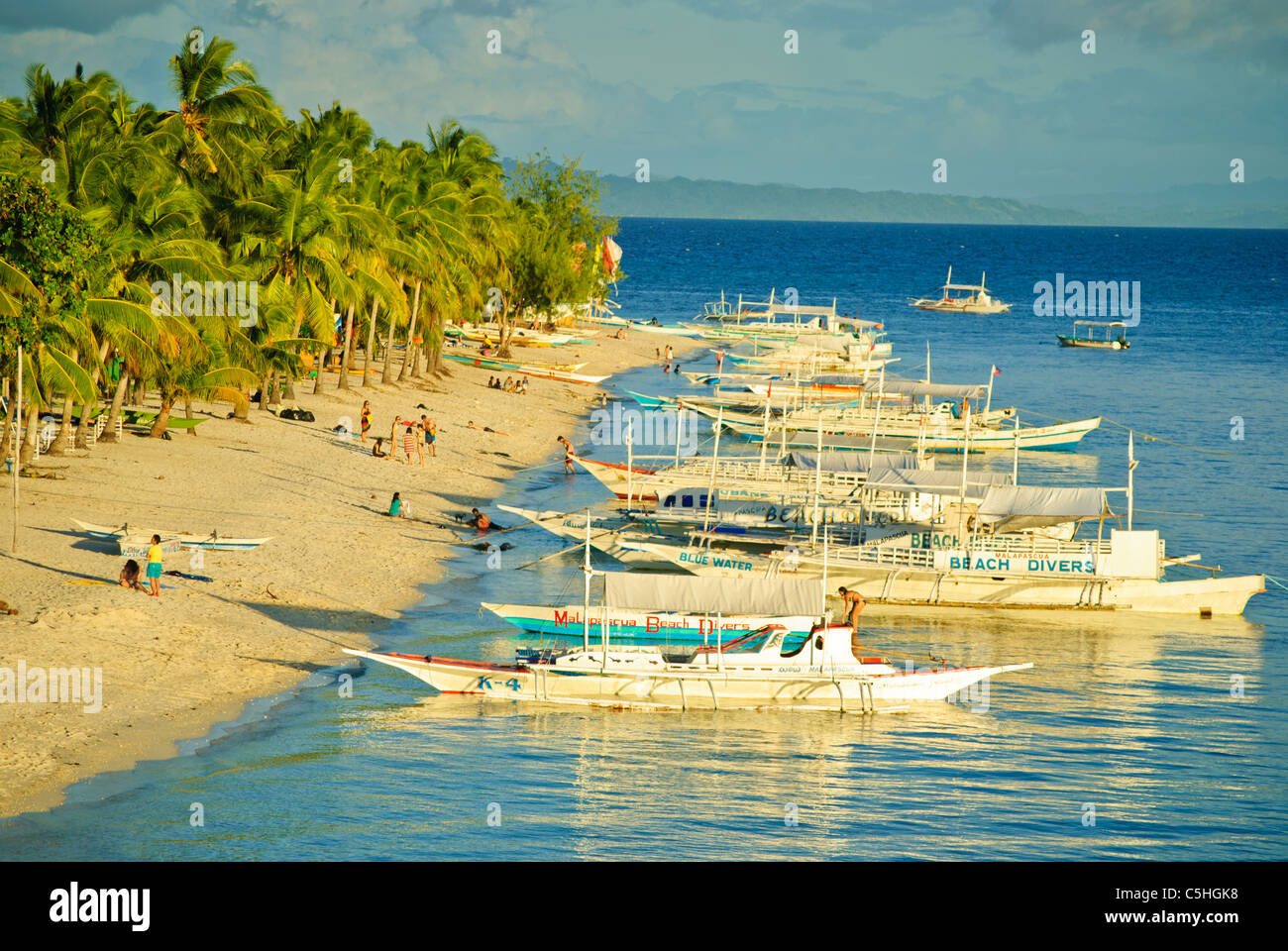 Ausleger als Tauchboote festmachen entlang des Strandes von Malapascua Island, Philippinen Stockfoto