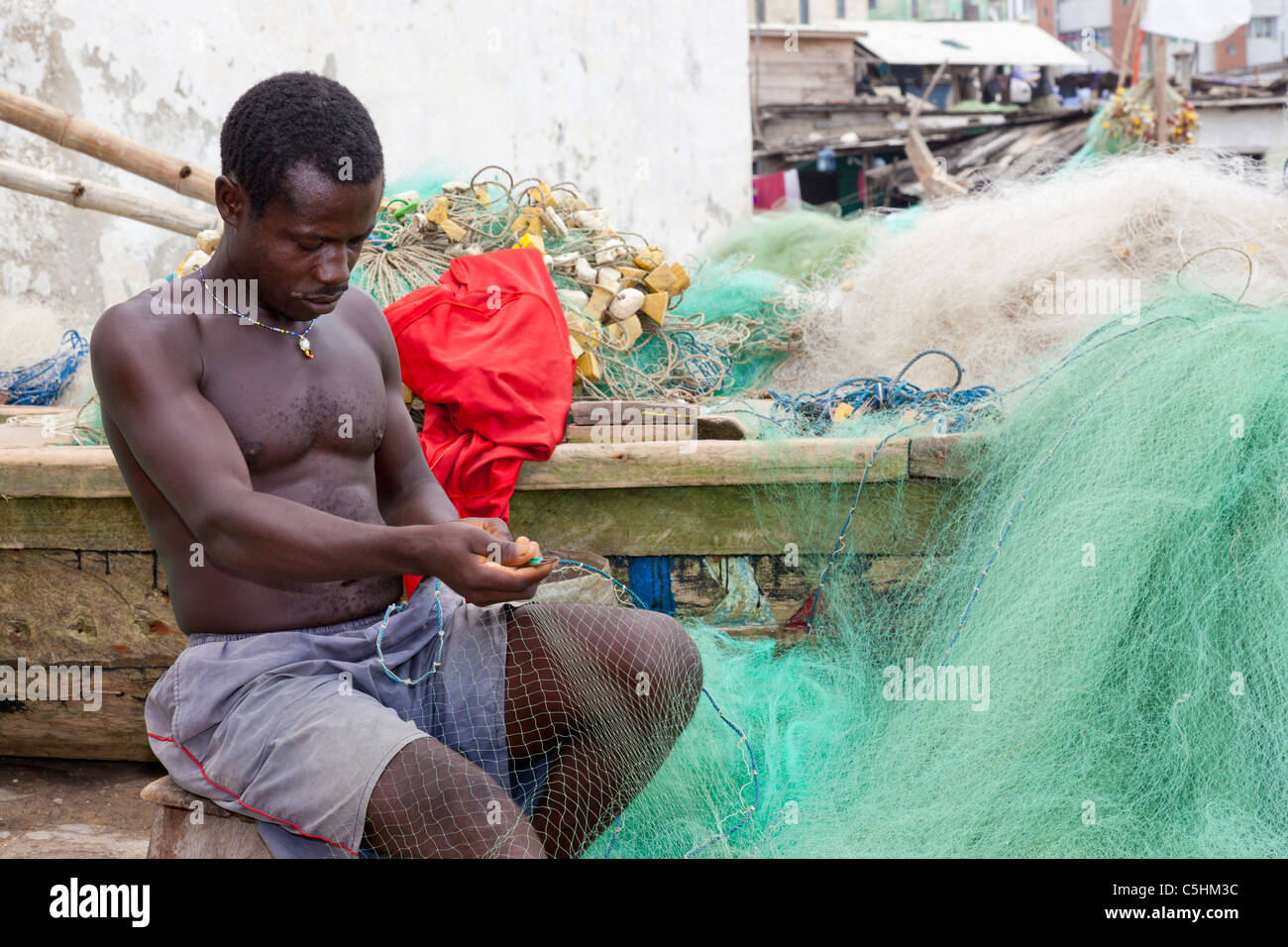 Afrikanischer Mann Reparatur ein Fischernetz. Cape Coast, Ghana Stockfoto
