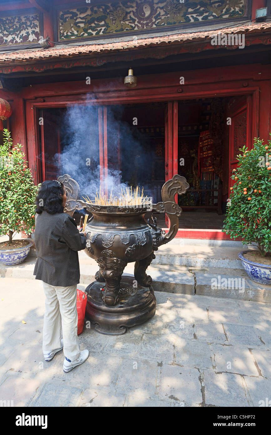 Frau Licht Weihrauch bietet im Ngoc Son-Pagode (Tempel des Jade Hügels), buddhistische Tempel auf der Insel am Hoan-Kiem-See, Hanoi Stockfoto