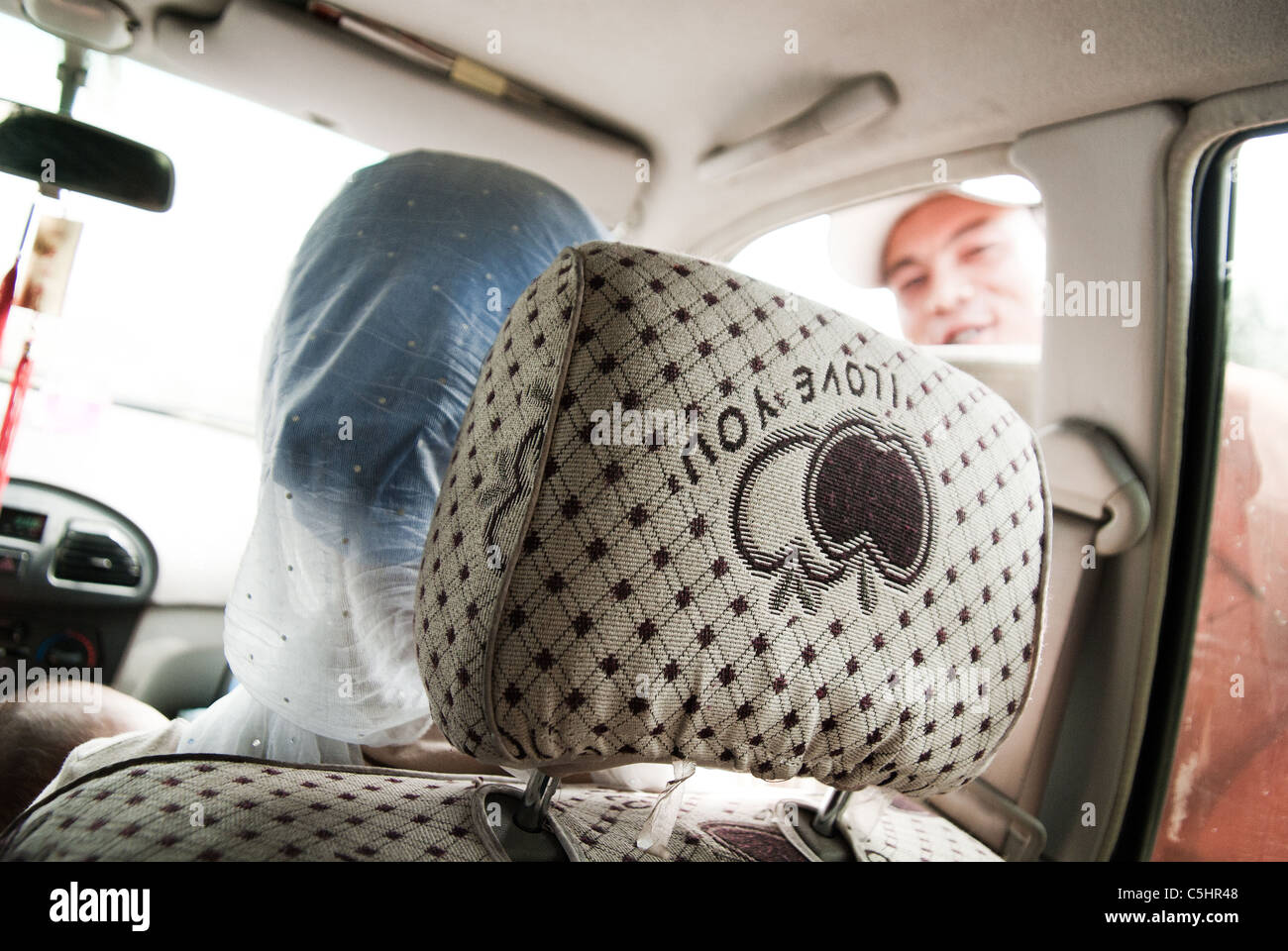 junger Bauer Abschied zu seiner Frau, als sie in die Stadt in ein Auto, Provinz Ningxia, China verlässt Stockfoto
