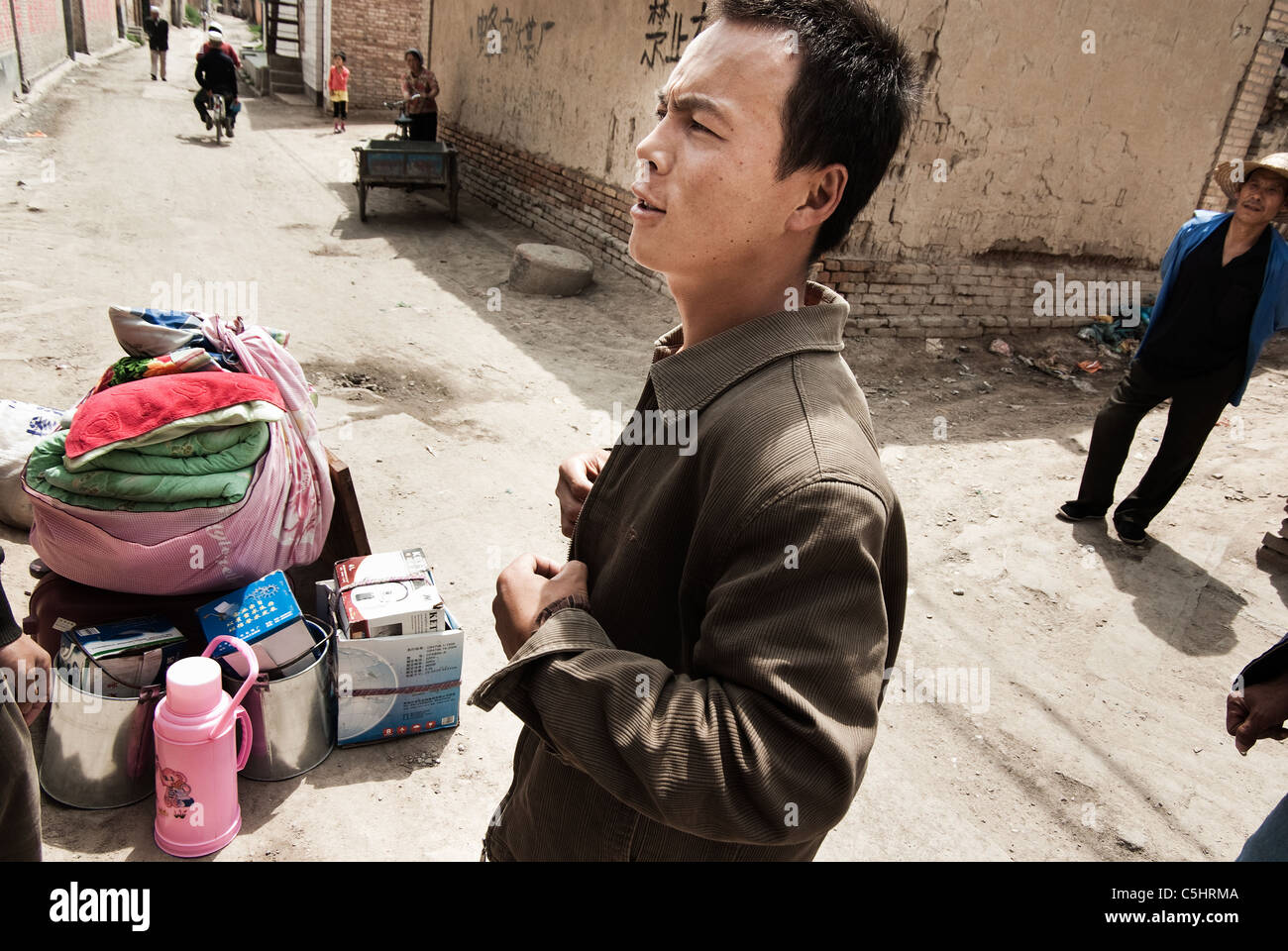 junger Bauer mit seinen Habseligkeiten bei der Ankunft in der Stadt Guyuan, ningxia Stockfoto