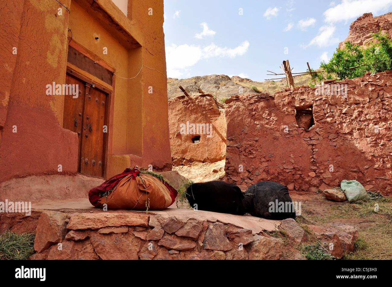 Bündel von Stroh und Luzerne für die Fütterung der Tiere vor einem alten Haus in Abyāneh Dorf, Isfahan Iran. Stockfoto