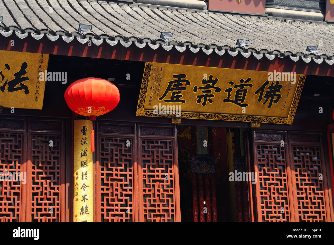 Gitter-Arbeit, kunstvoll gefliesten Dach, rote Laterne und beschrifteten Motto über dem Eingang zum jade Buddha Pavillon, Jade Stockfoto