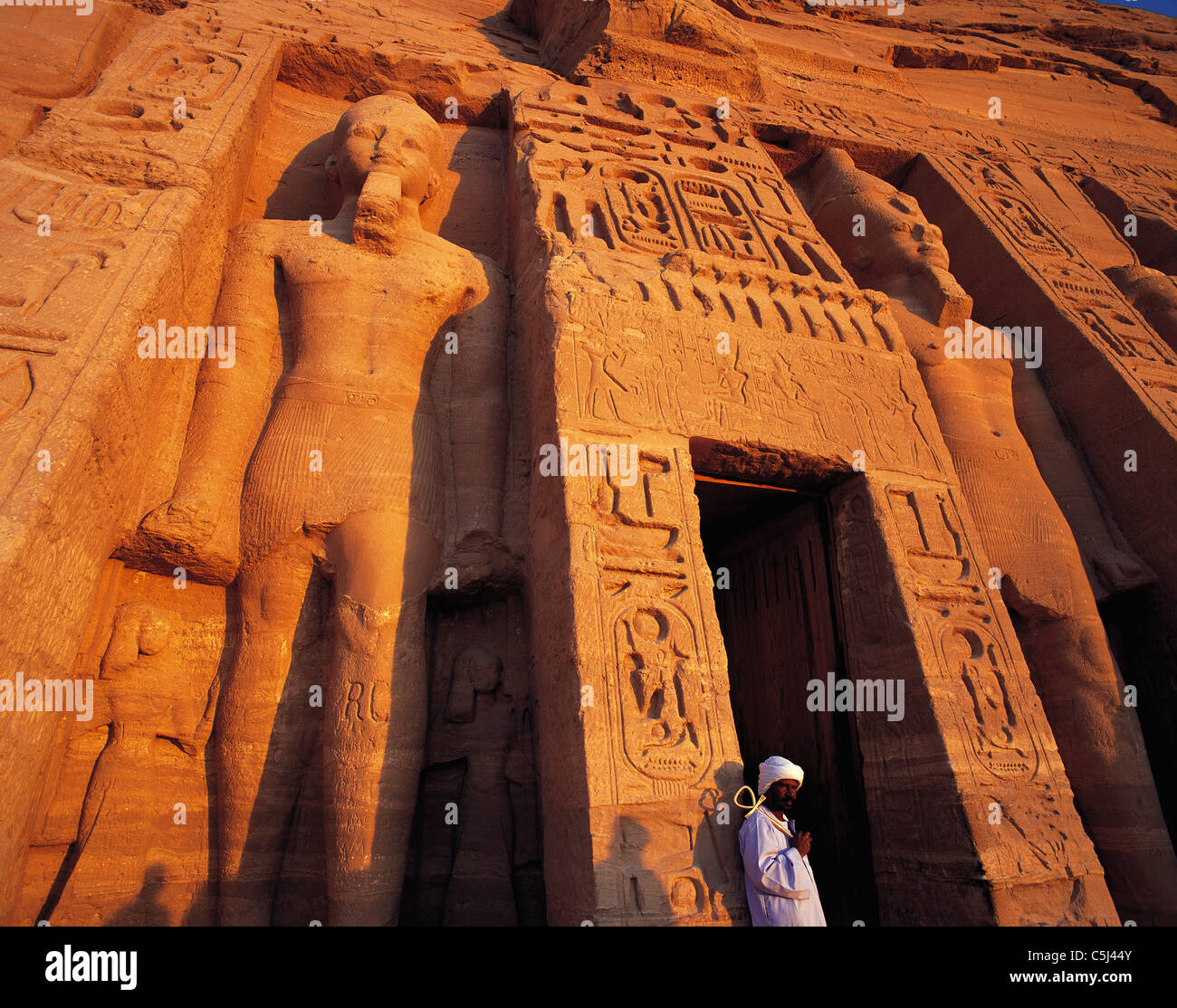 Weitwinkel Schuss der Eingang zum Heiligtum zu Ramses II in Abu Simbel, mit geschnitzten Fries und Statue und Wächter Stockfoto