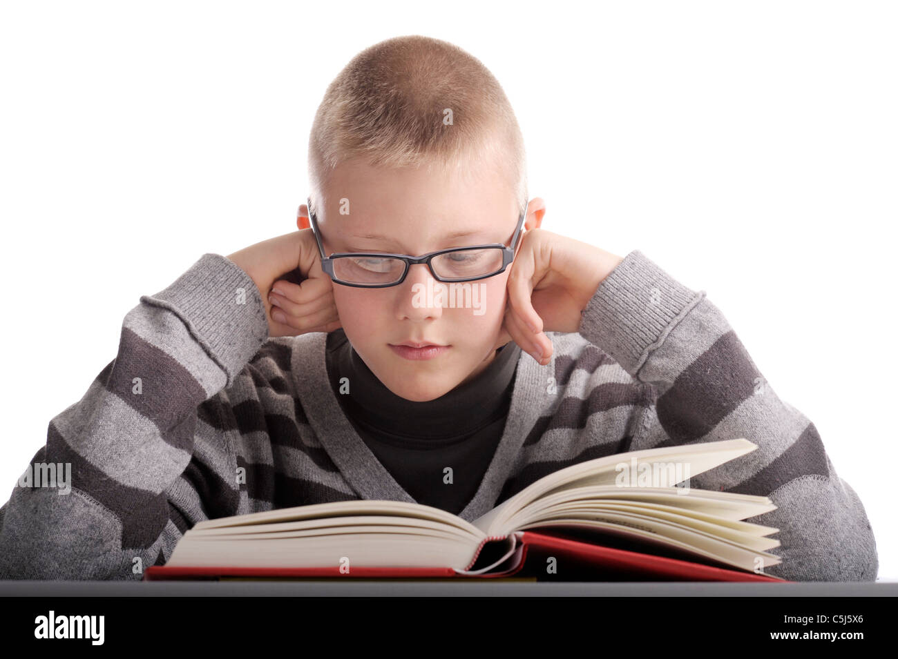 Junge, ein Buch zu lesen. Kopf auf die Hände. isoliert auf weiss Stockfoto