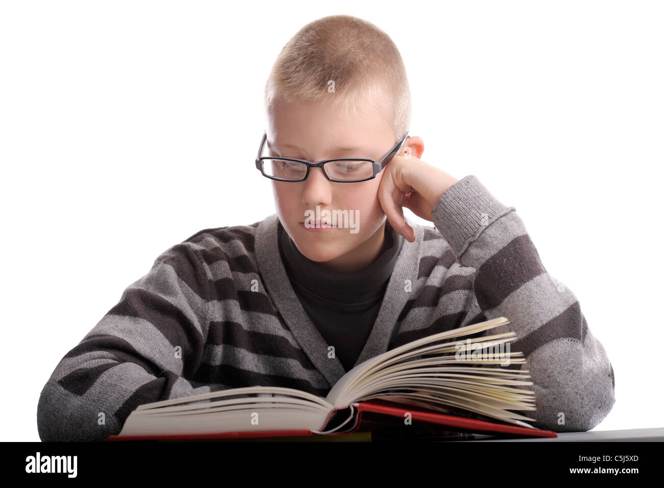 Junge, ein Buch zu lesen. Kopf auf seine Hand. isoliert auf weiss Stockfoto