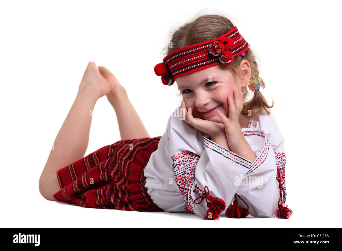 Kleines Mädchen in die ukrainische Tracht auf dem Bauch liegend Stockfoto