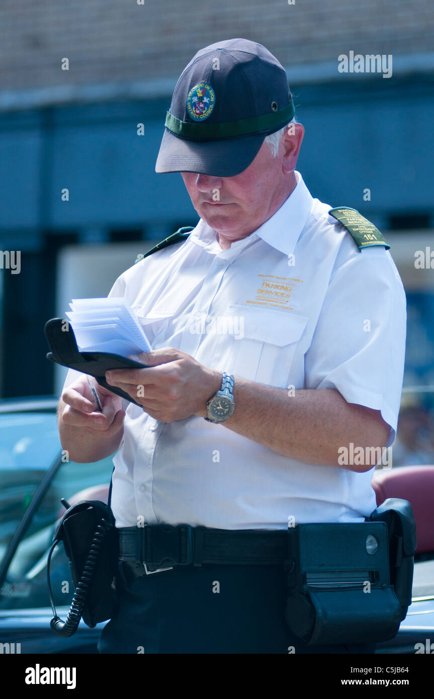Ein Traffic Warden ein Ticket für ein falsch geparktes Auto schreiben. Stratford on Avon. UK Stockfoto