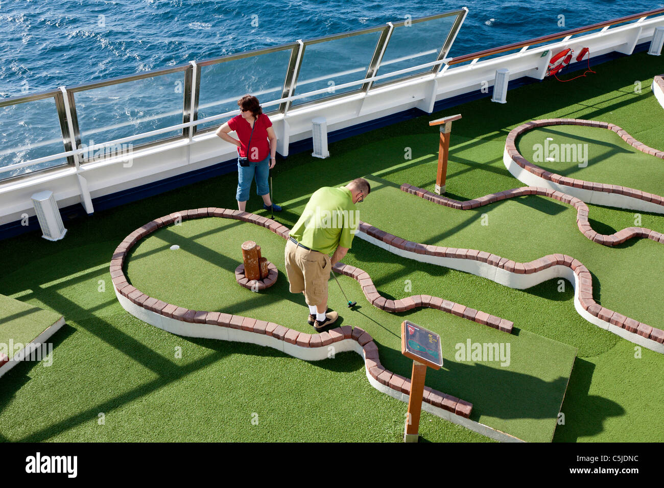 Kreuzfahrt-Passagiere spielen Minigolf auf dem Deck des Kreuzfahrtschiffes Carnival Triumph im Golf von Mexiko Stockfoto