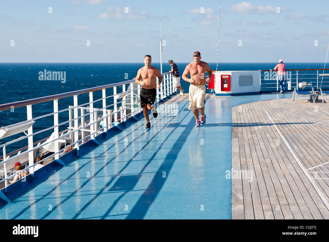 Zwei Männer laufen auf jogging-Strecke auf dem Sport Deck der Carnival Triumph Kreuzfahrtschiff im Golf von Mexiko Stockfoto