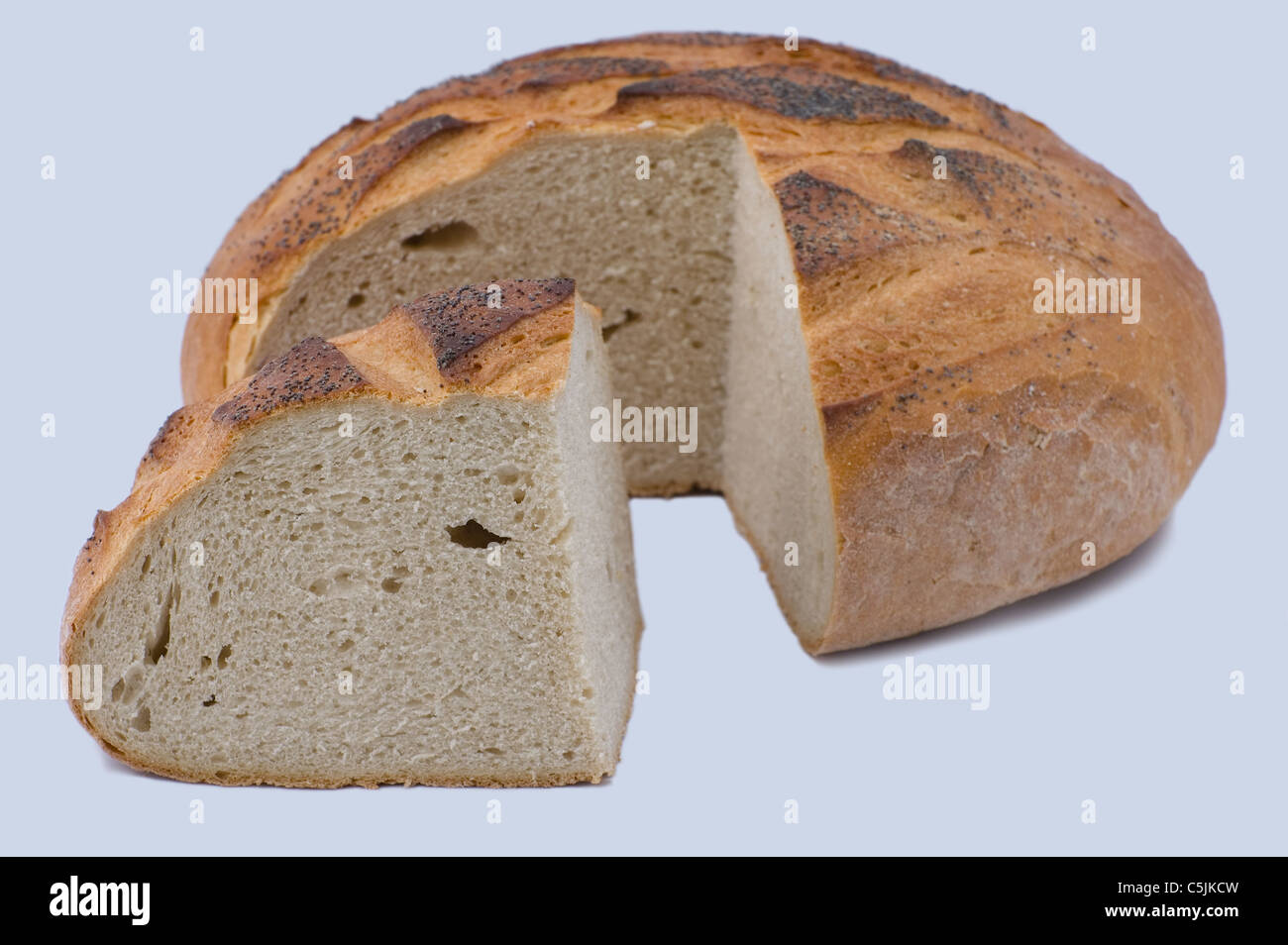 Schneiden Sie rundes Laib Brot mit Mohnöl auf weißem Hintergrund Stockfoto