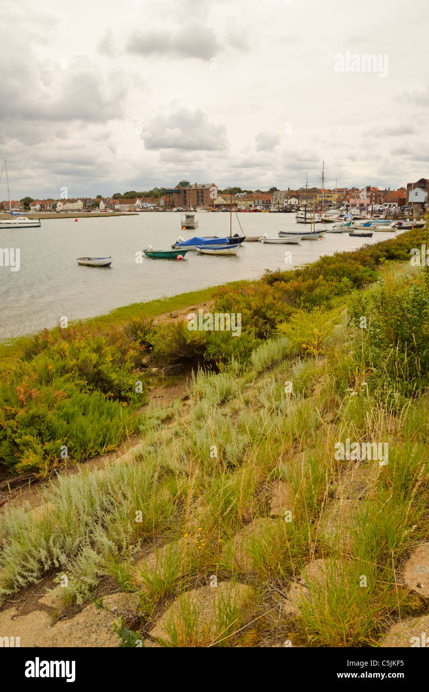 Brunnen neben dem Meer Hafen mit Booten und Ufermauer North Norfolk Stockfoto