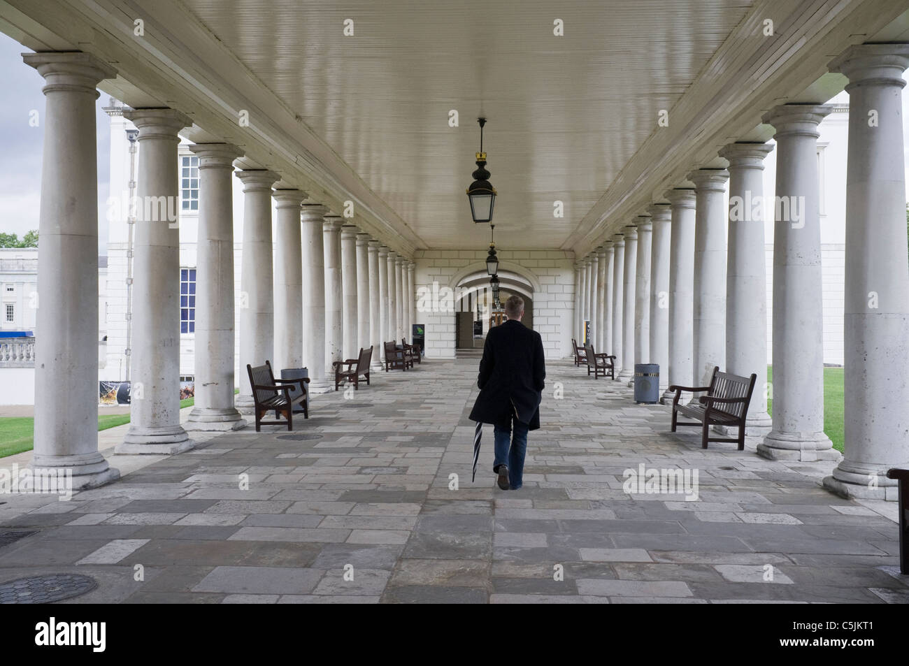 Greenwich, London, England, Vereinigtes Königreich, Großbritannien. Mann zu Fuß durch die Kolonnade des National Maritime Museum, The Queen House Stockfoto