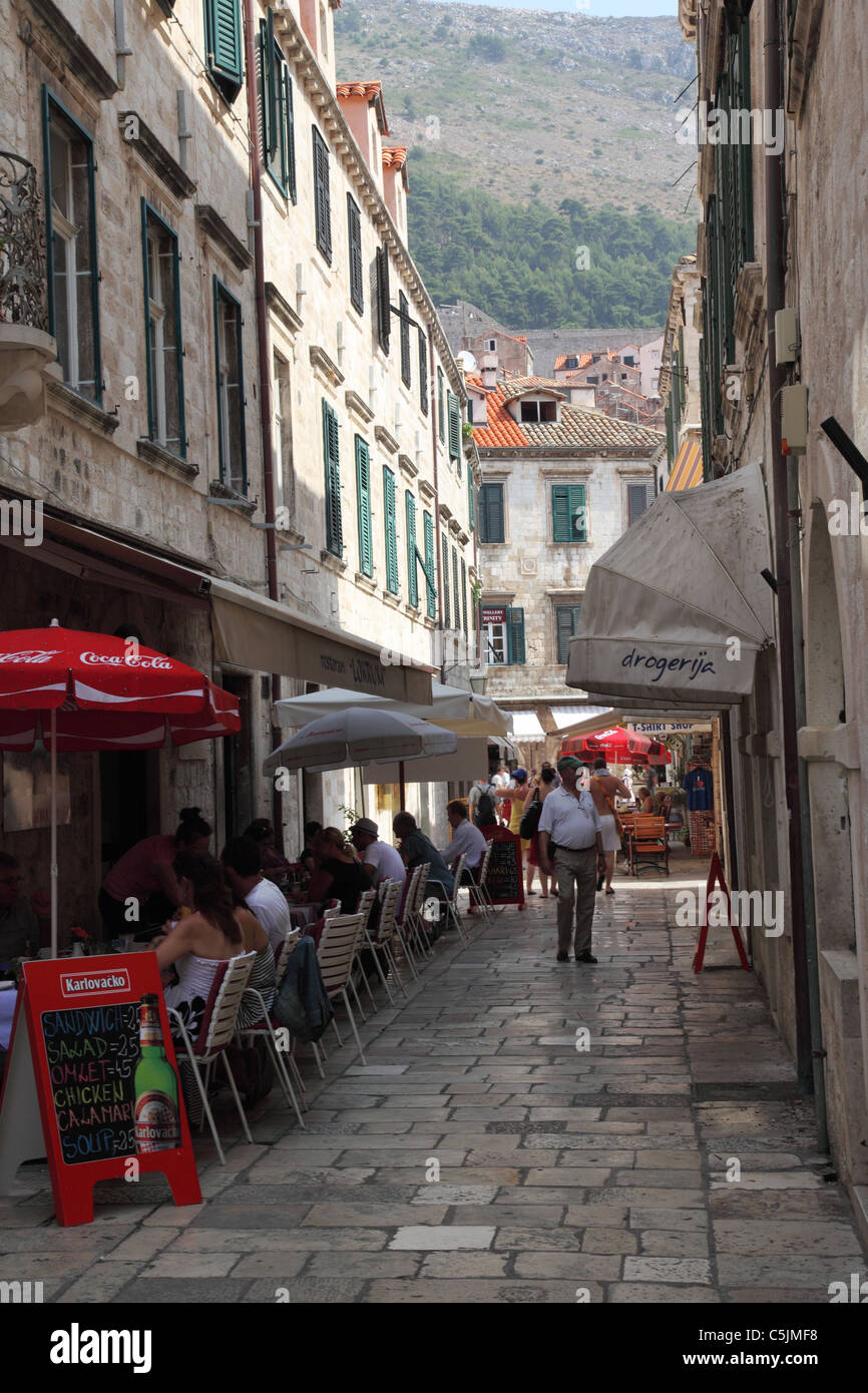 Eine schmale Straße mit Cafés und Restaurants in der Altstadt von Dubrovnik, Kroatien Stockfoto