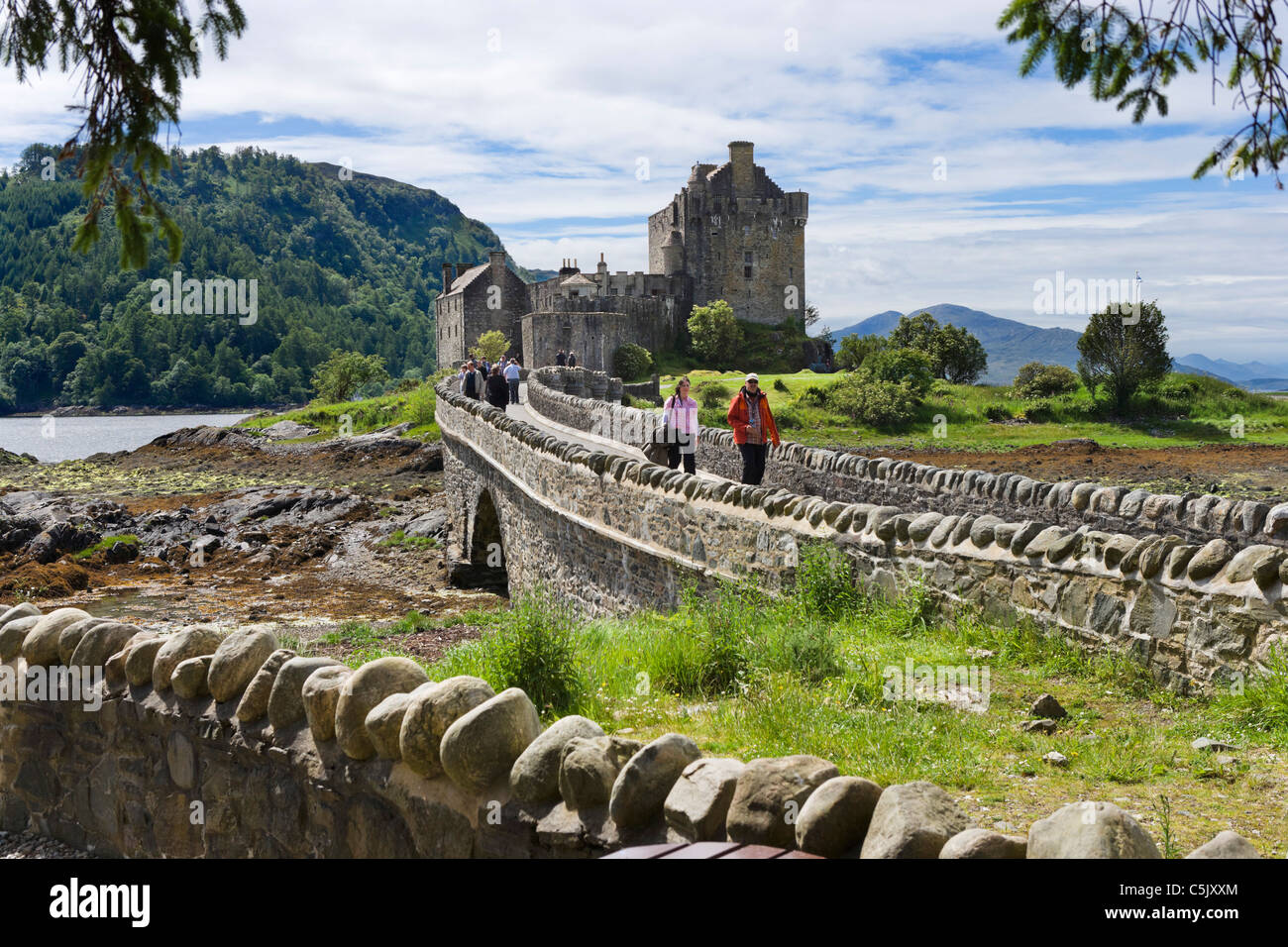 Touristen, die über die Brücke zum Eilean Donan Castle, Loch Duich, Highland, Schottland, UK Stockfoto