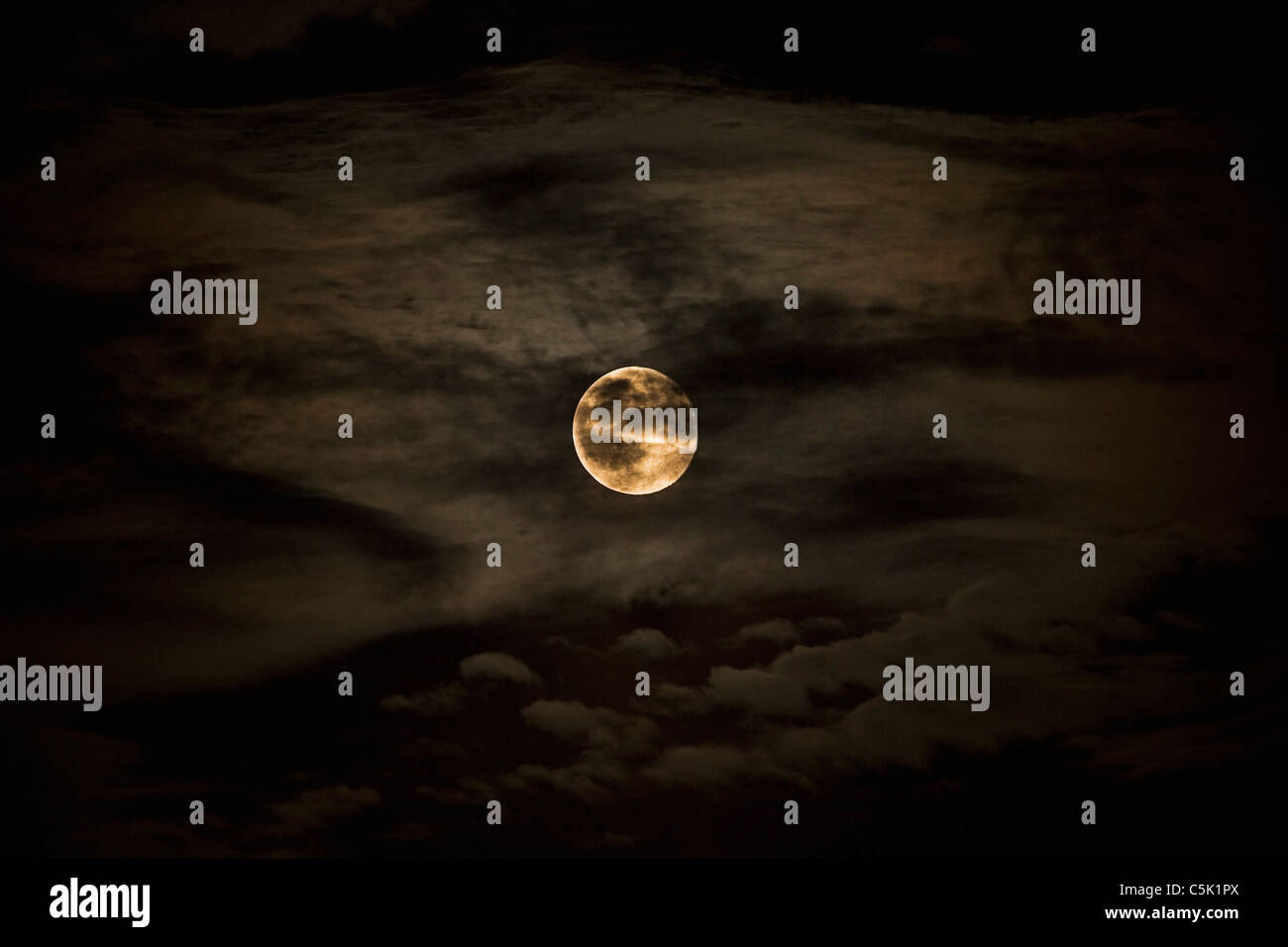 Vollmond hinter Wolken warme gelbe Farbe Stockfoto