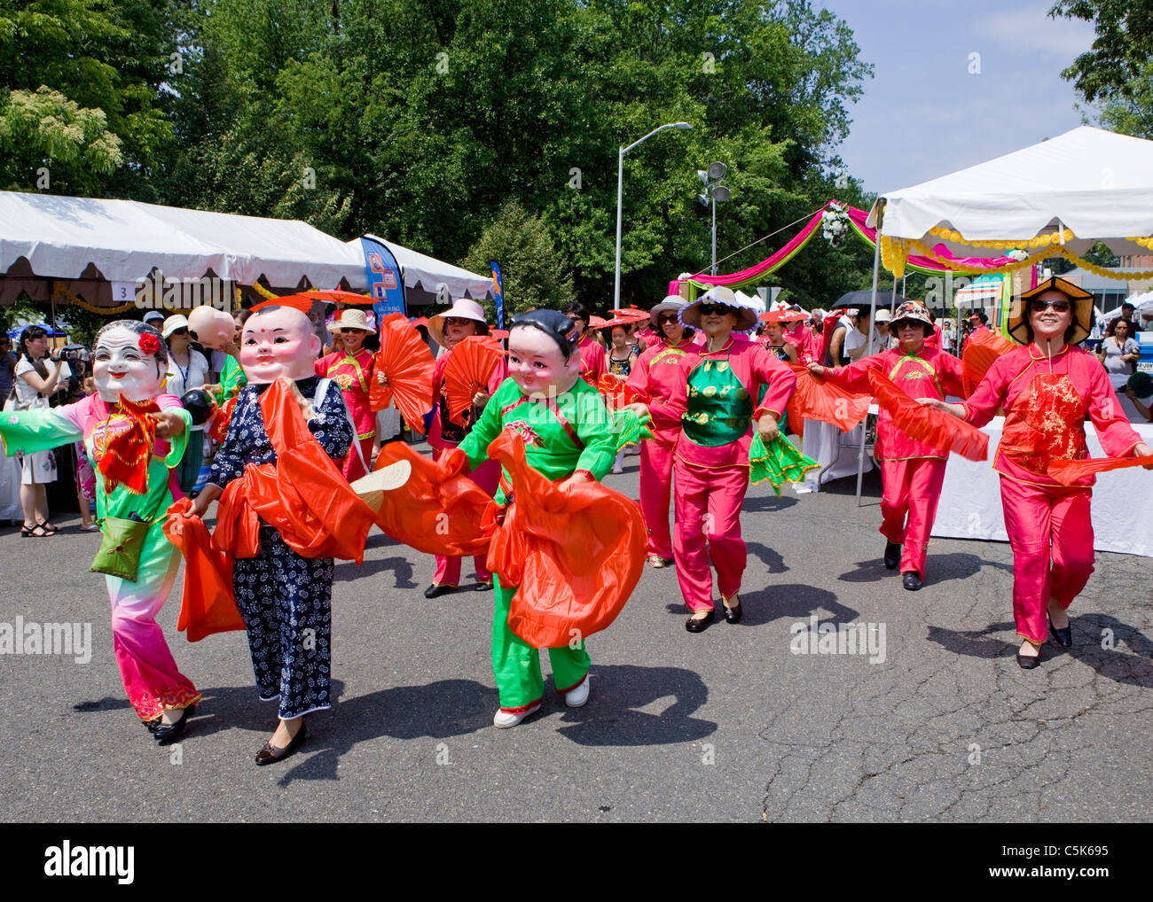 Chinesische Frauen in Kostümen und Masken in parade Stockfoto