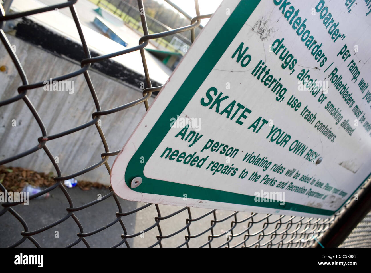 Ein Schild an der Skate-Park stellt klar, dass man auf Ihr eigenes Risiko Schlittschuh laufen werden. Geringe Schärfentiefe. Stockfoto