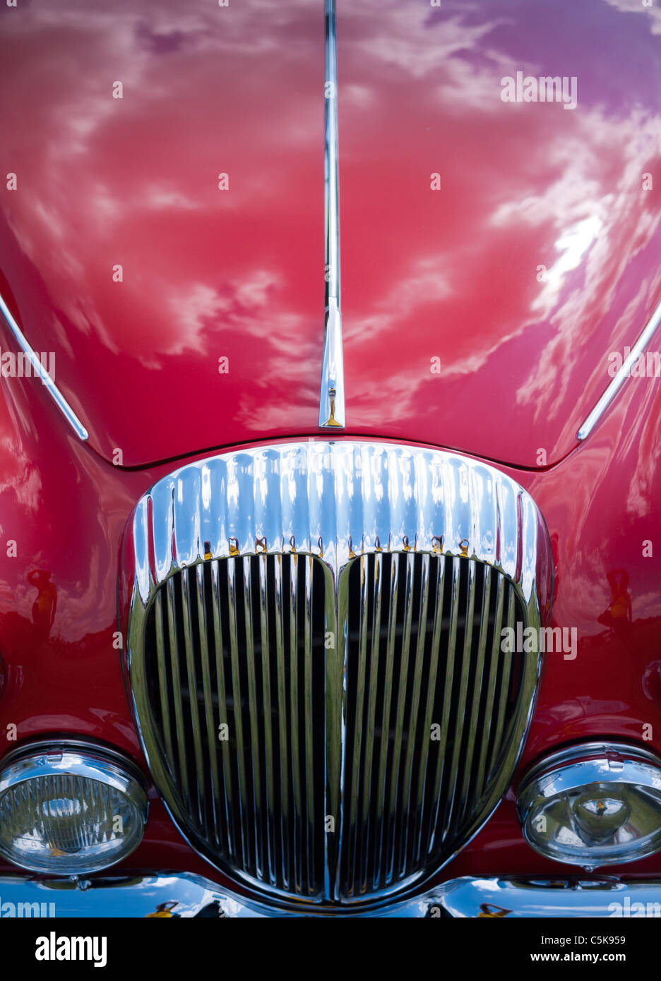 Nahaufnahme von roten Jaguar Motorhaube mit Wolken spiegeln sich in glänzenden Lack-Arbeit Stockfoto