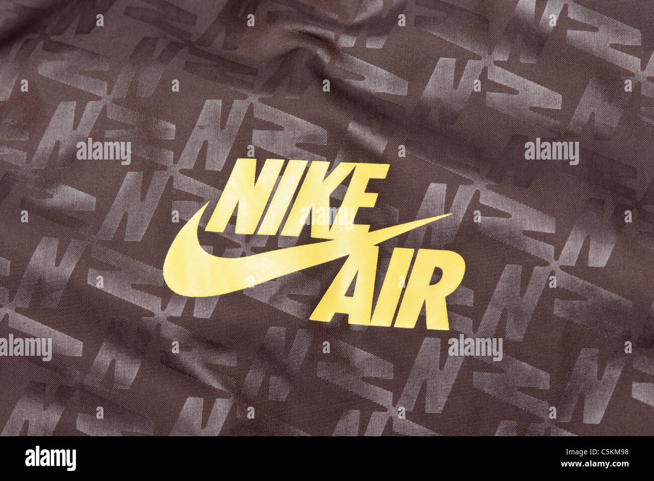Mens Nike Air Windrunner Sportswear nylon Regenjacke Jacke in braun mit gelben Logo und alle über Drucken detail. Stockfoto