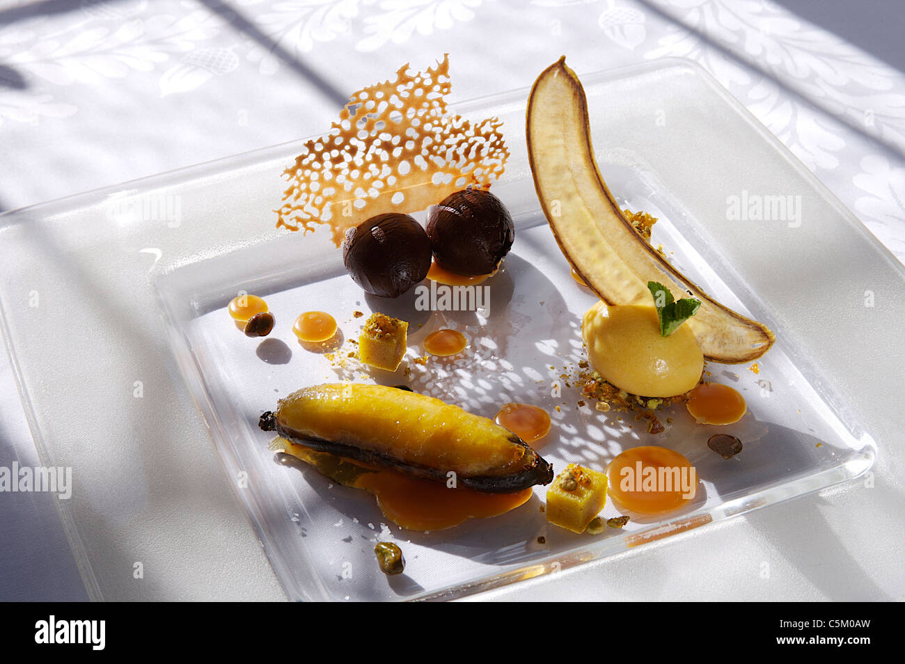 Schokolade und Olivenöl Trüffel mit gebackene Banane auf dem Milchglas Silbertablett serviert. Stockfoto
