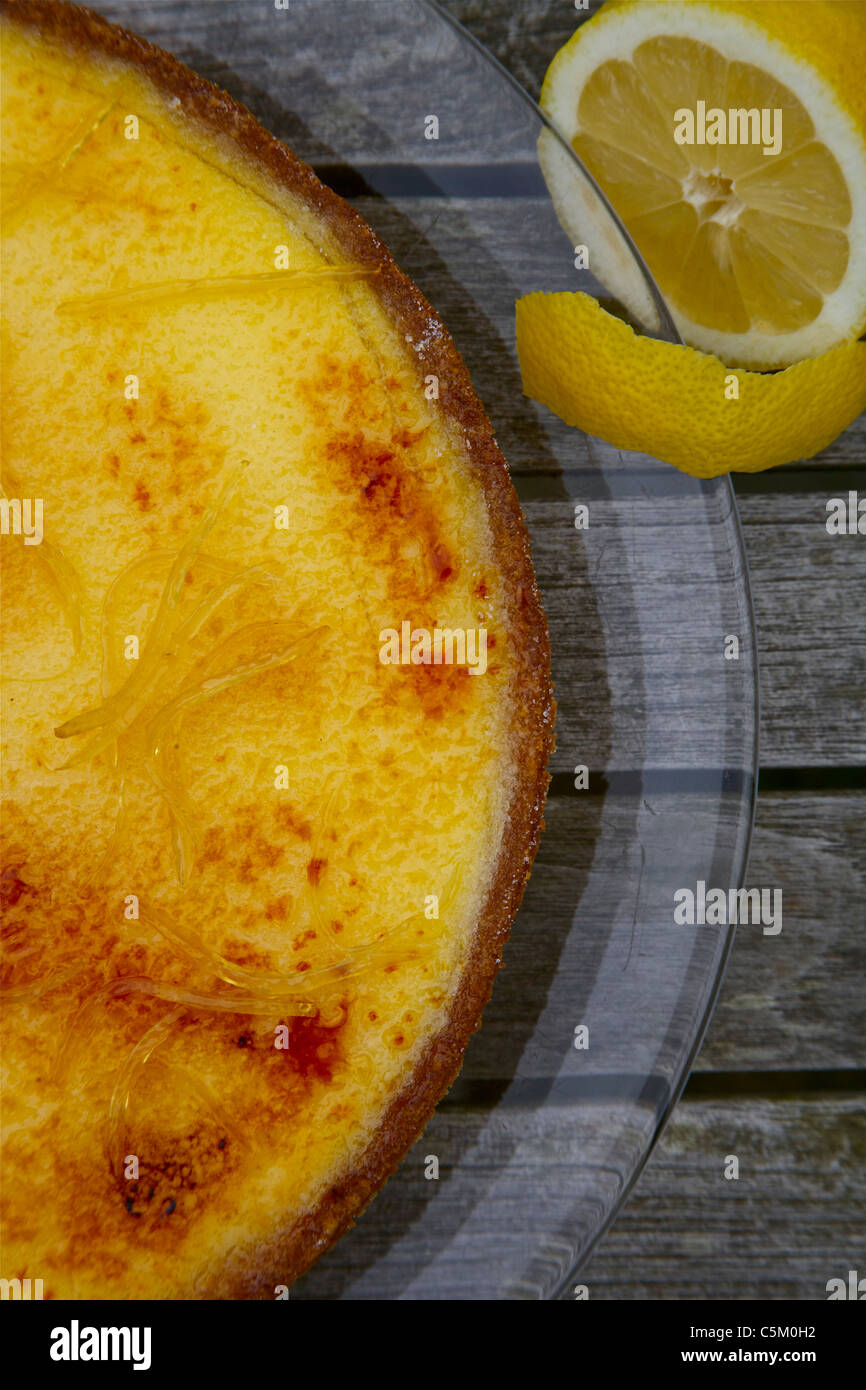 Zitrone und Puddingtörtchen auf einer Glasplatte Stockfoto
