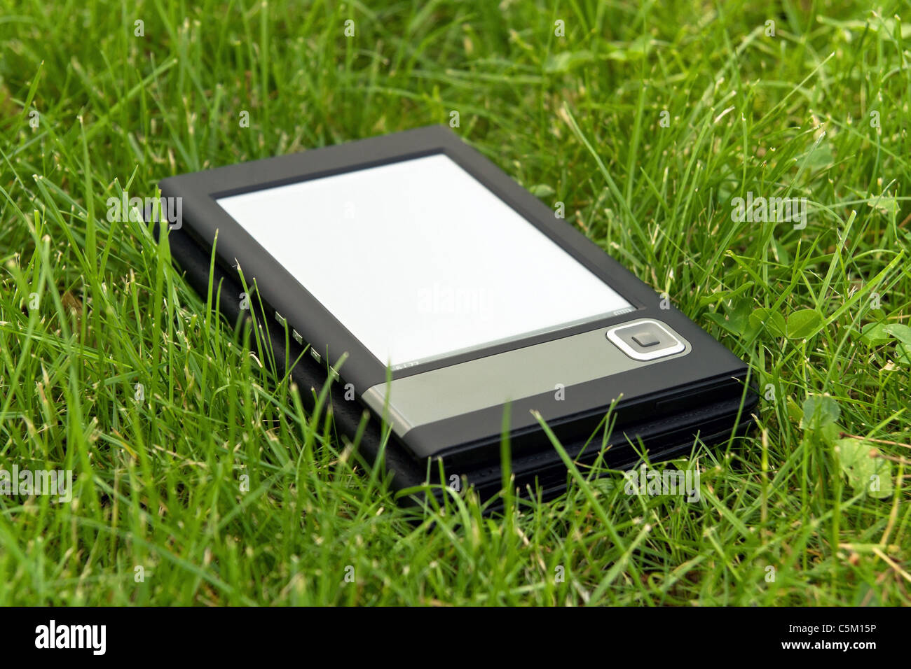 Tragbare elektronische Buch auf dem Rasen liegen. Geringe Schärfentiefe. Stockfoto