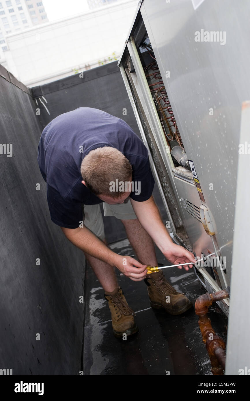 Eine HLK Heizung Lüftung Klimaanlage Techniker reparieren oder die Aufrechterhaltung einer großen Gewerbeeinheit. Stockfoto