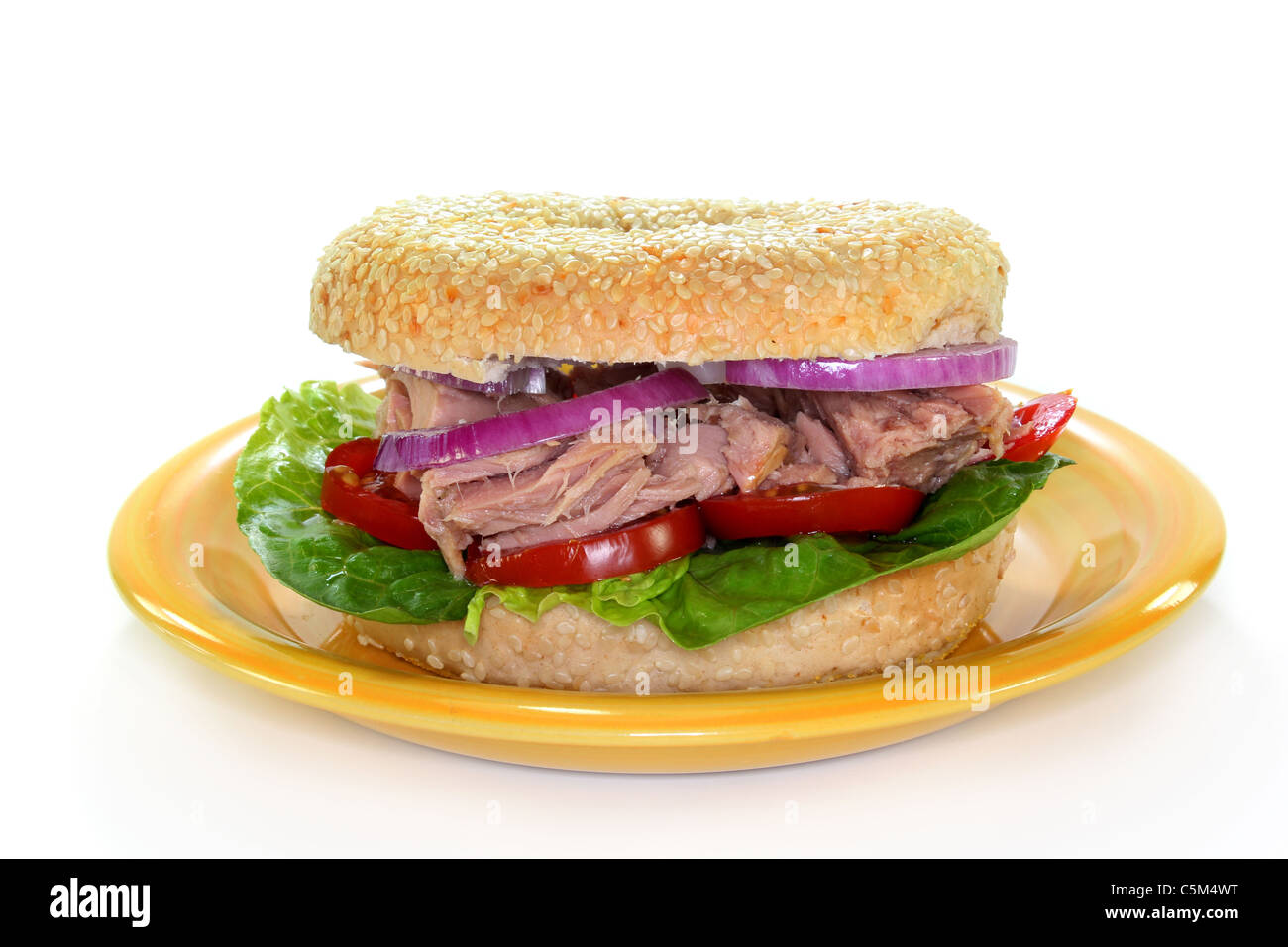 ein Bagel garniert mit Thunfisch, Zwiebeln und Tomaten Stockfoto