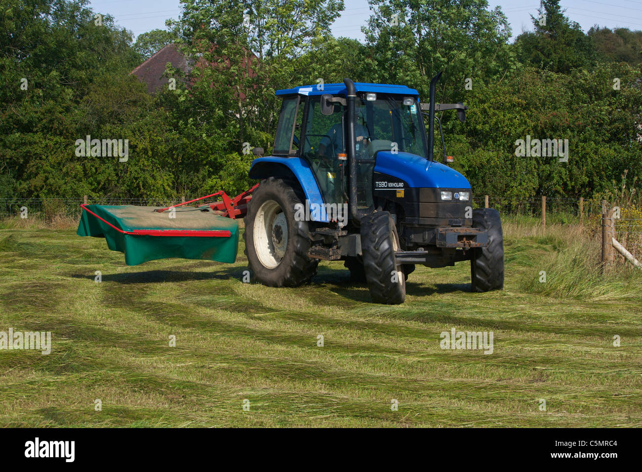 Mähen Heu mit einem New Holland TS90 4WD Trommel Traktor & eine Kverneland Taarup 1116 Mäher Stockfoto