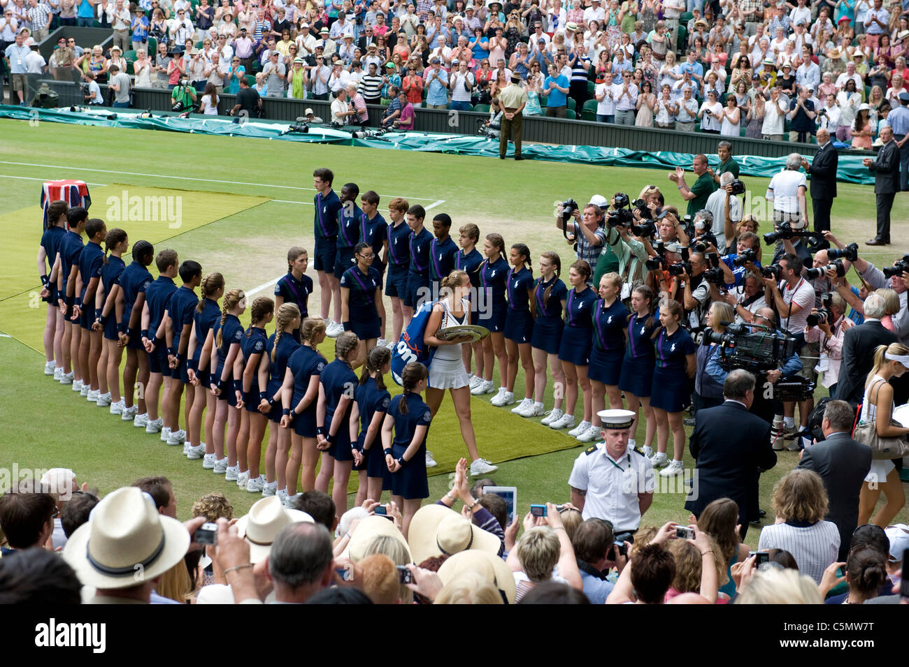 Spieler gehen Sie durch die Linie der Ball jungen und Mädchen nach bei den 2011 Wimbledon Tennis Championships Finale Damen Stockfoto