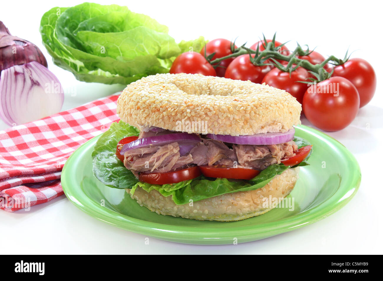 ein Bagel garniert mit Thunfisch, Zwiebeln und Tomaten Stockfoto
