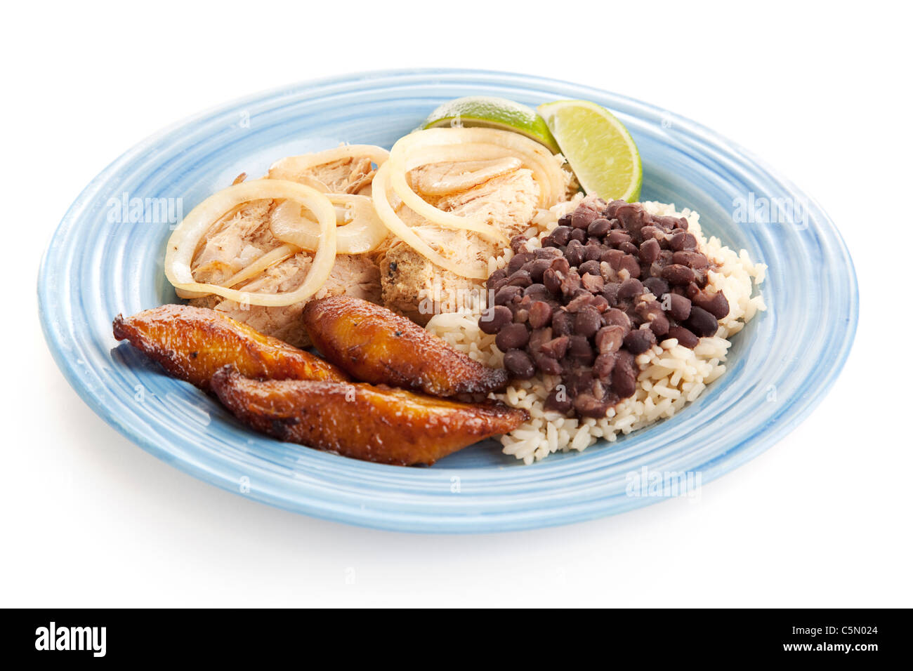 Kubanische Speisen mit Schweinebraten, schwarze Bohnen und Reis und gebratenen Kochbananen. Isoliert auf weißem Hintergrund Stockfoto