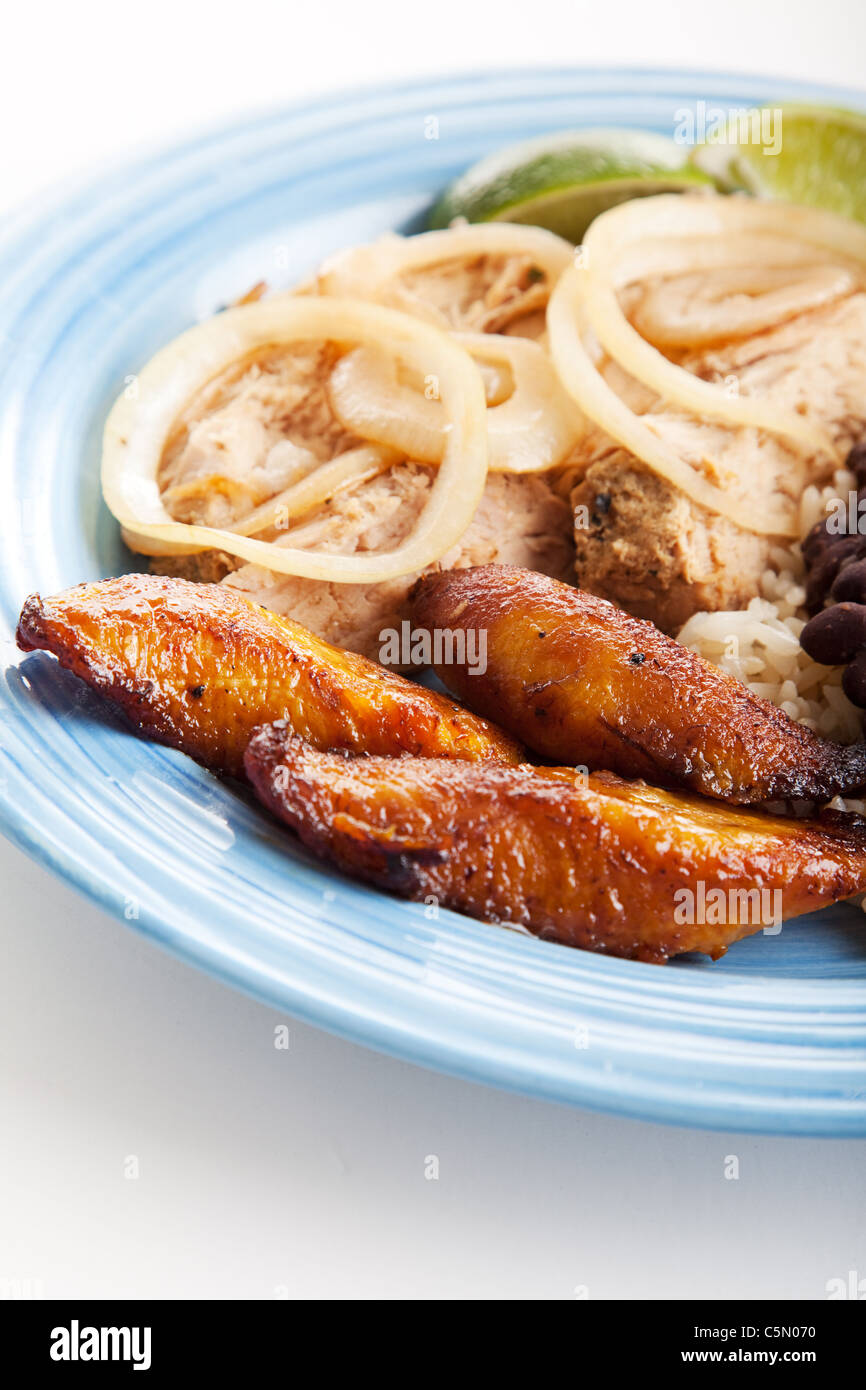 Teller mit kubanischen Essen mit gebratene süße Stockton, Braten Hafen und schwarzen Bohnen & Reis. Konzentrieren Sie sich auf das Hauptanbauprodukt. Stockfoto