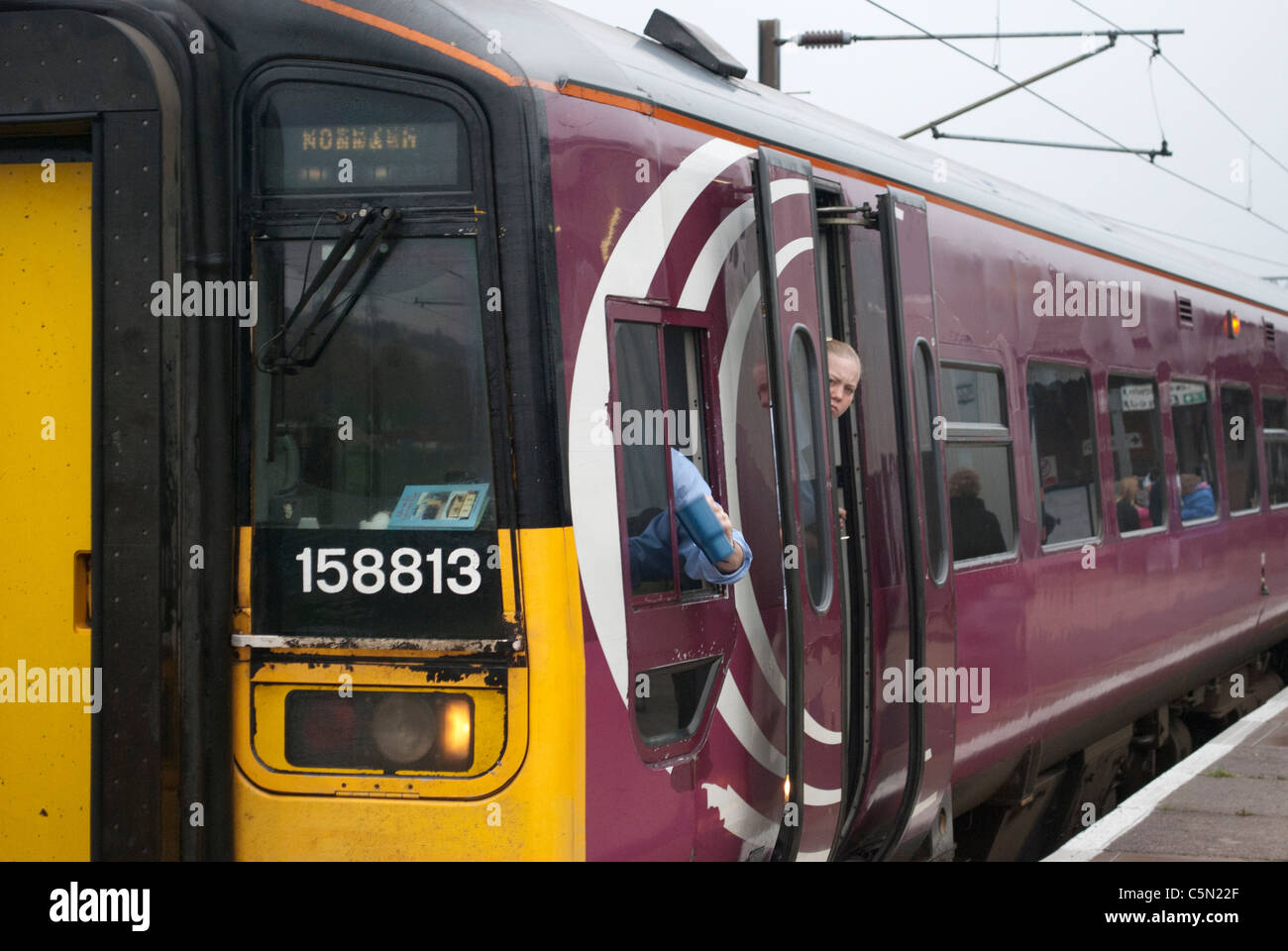 East Midlands Züge (EMT) Zug 158813 158 Klasse Grantham Bahnhof auf Weg nach Norwich und bewachen ein böses Gesicht aus offenen Tür Stockfoto