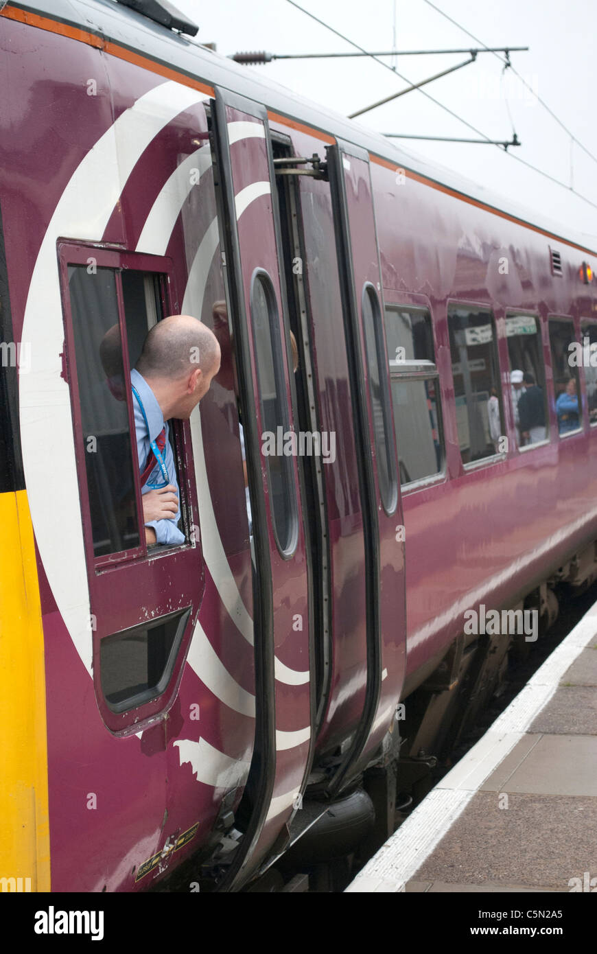 East Midlands Züge (EMT) Zug 158813 158-Klasse in Grantham Bahnhof auf Weg nach Norwich mit Fahrer aus Fenster gelehnt Stockfoto