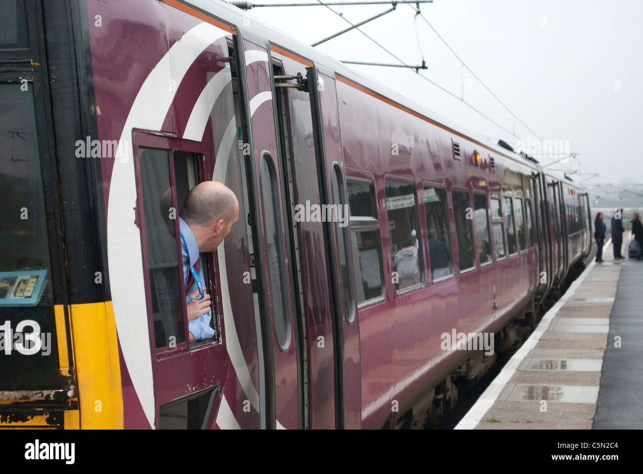 East Midlands Züge (EMT) Zug 158813 158-Klasse in Grantham Bahnhof auf Weg nach Norwich mit Fahrer aus Fenster gelehnt Stockfoto