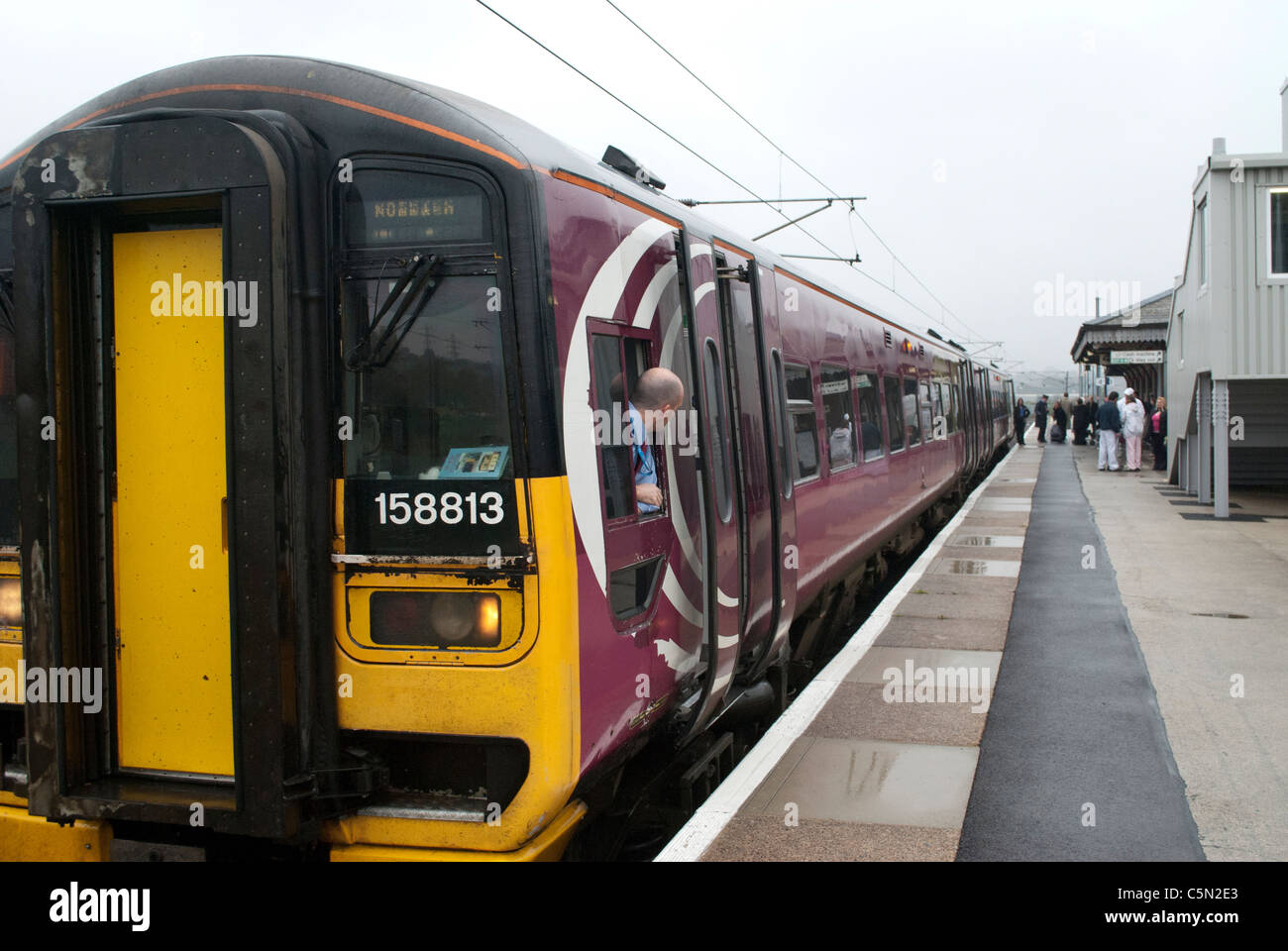 East Midlands Züge (EMT) Zug 158813 158-Klasse in Grantham Bahnhof auf Weg nach Norwich mit Fahrer aus dem Fenster gelehnt Stockfoto