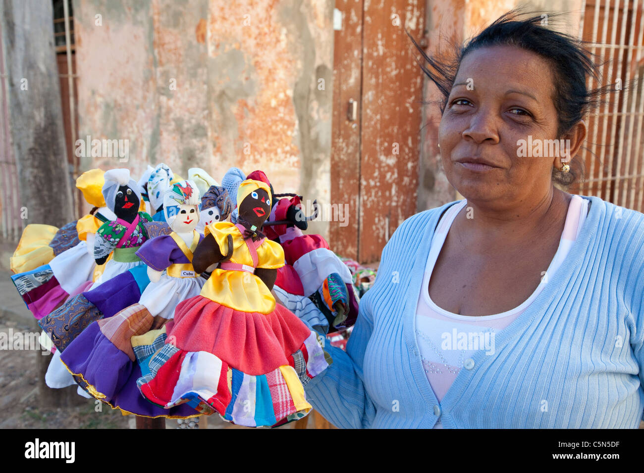 Kuba, Trinidad. Dame mit handgemachten Puppen in Handwerksmarkt. Stockfoto