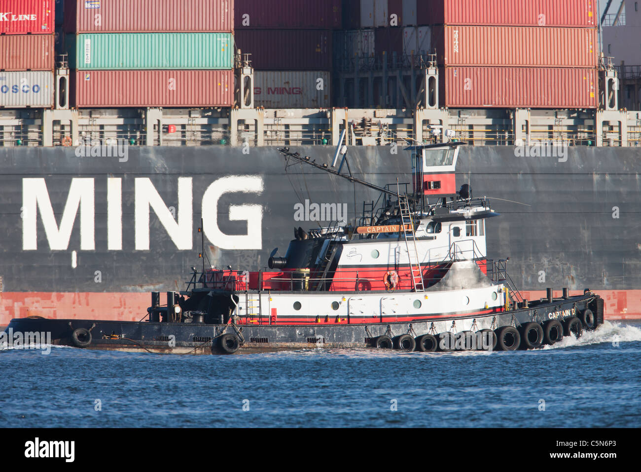 Ein Schlepper weitergibt Yang Ming-Container-Schiff angedockt an der Newark Bay. Stockfoto