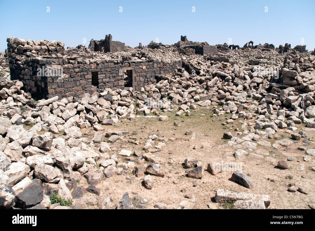 Basaltsteinruinen in der antiken Stadt und archäologische Stätte von Umm el-Jimal in der Wüste Badia im Norden Jordaniens. Stockfoto