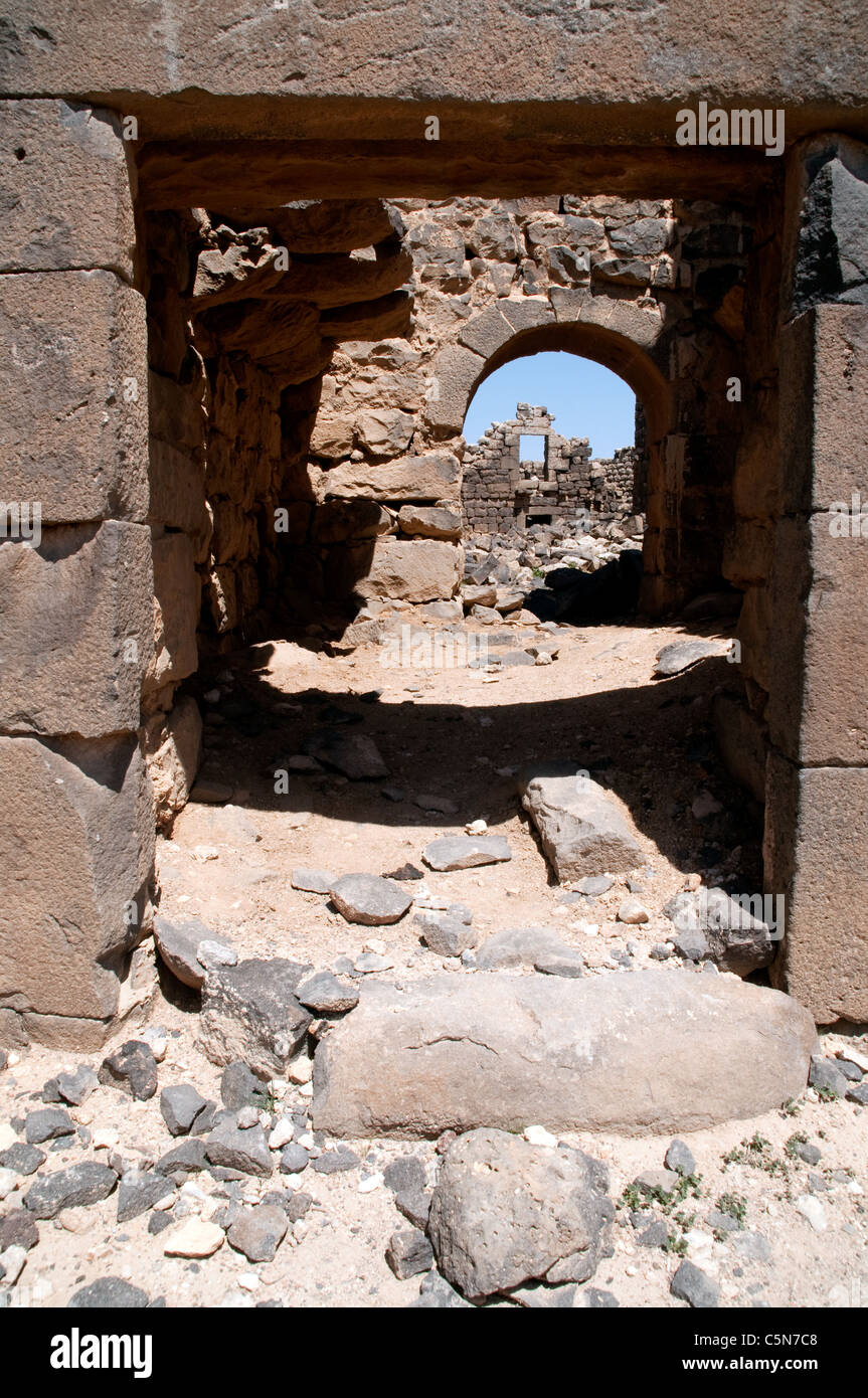 Die Basaltsteinruinen eines Hauses in der antiken Stadt und archäologische Stätte von Umm el-Jimal in der Wüste Badia im Norden Jordaniens. Stockfoto