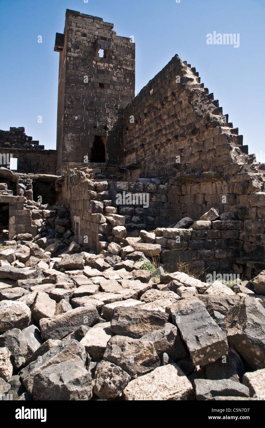 Ein Basaltsteinturm und eine Mauer in der antiken Stadt und archäologische Stätte von Umm el-Jimal in der Wüste Badia im Norden Jordaniens. Stockfoto
