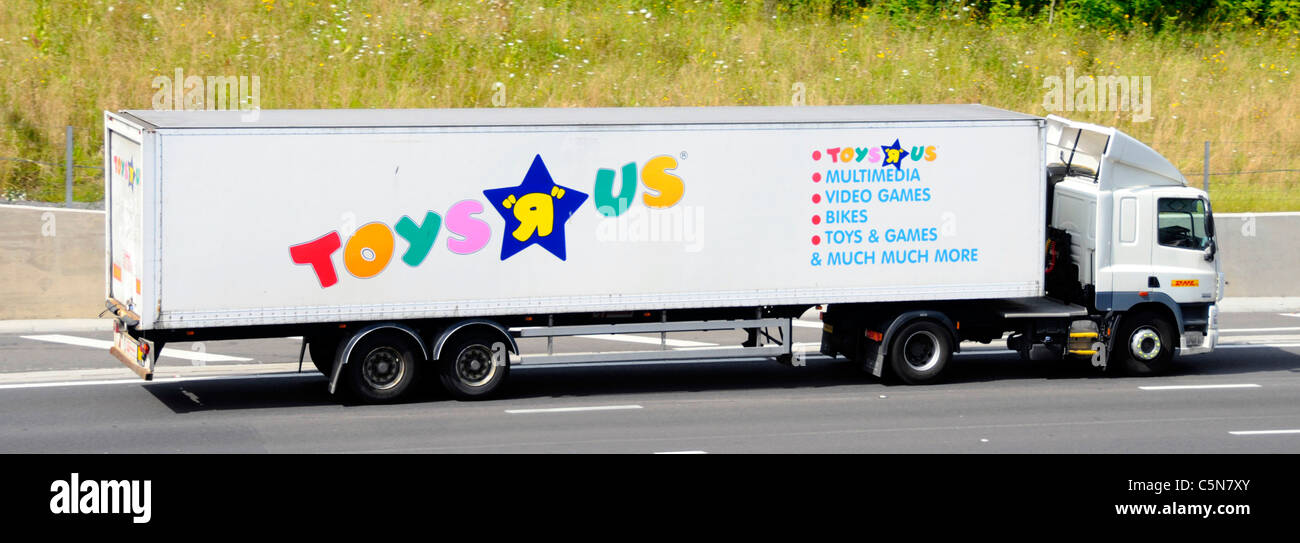 Seite der Spielzeuglieferkette Transport über artikuliert trailer Werbung Toys R Us Retail Stores & Logo mit Lkw DHL Lkw Lkw auf de Autobahn Stockfoto